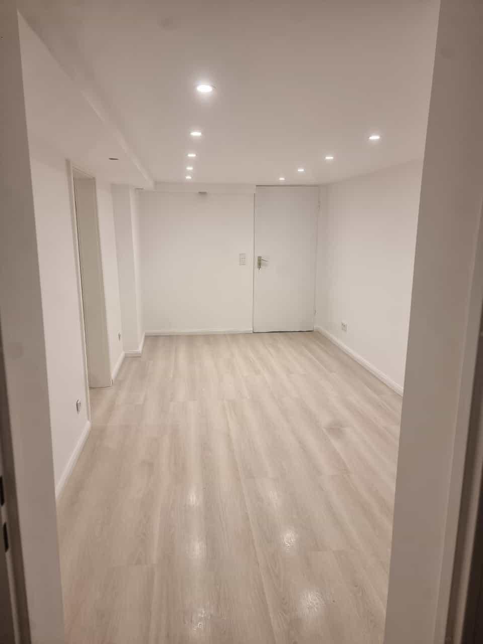 Fertig renovierter Innenraum mit neuem Boden und moderner Beleuchtung.