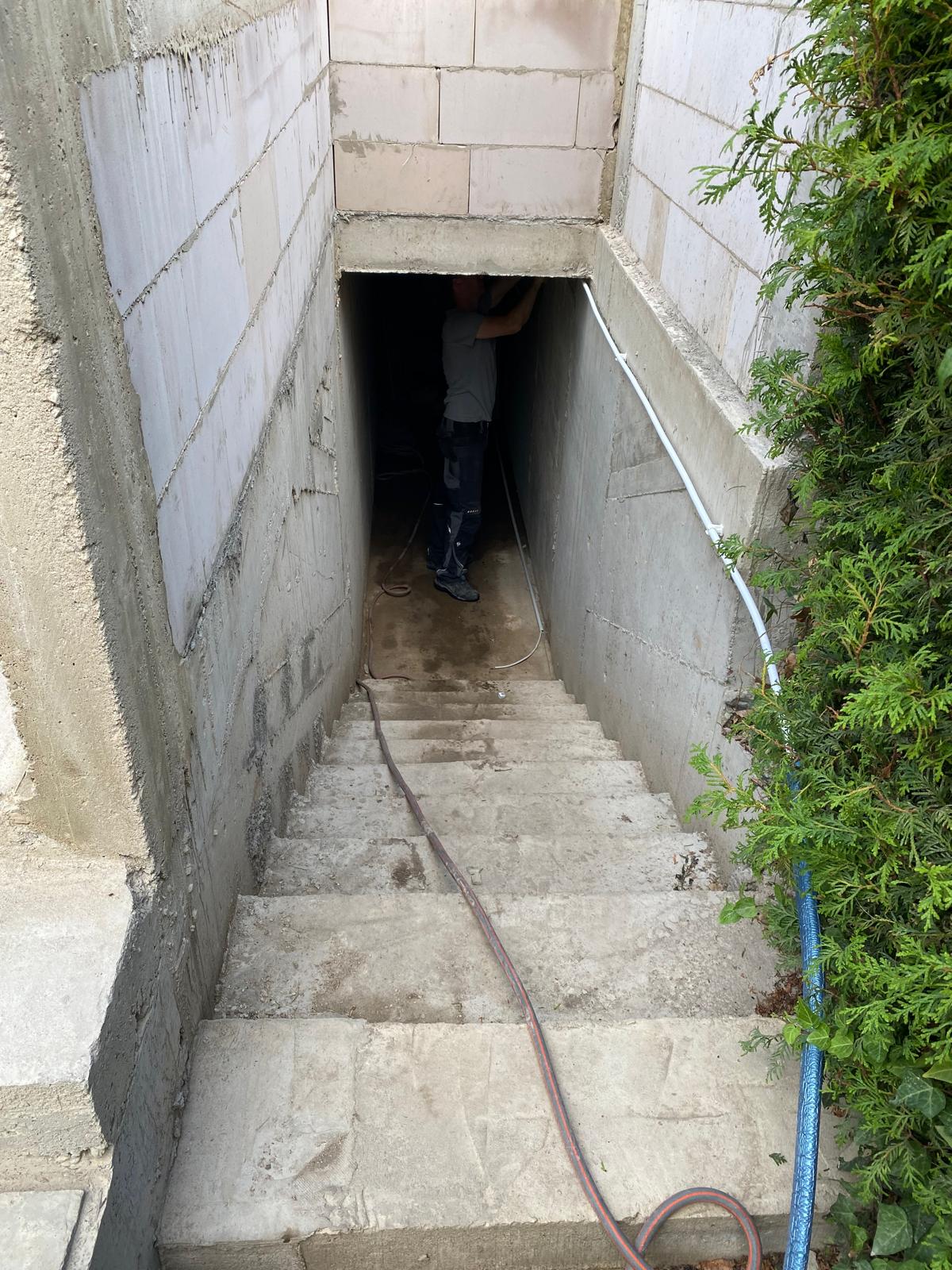 Neu errichteter Kellerabgang mit massiven Wänden und Treppe.